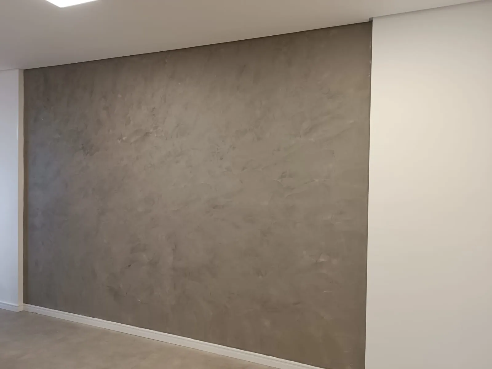 Parede de sala em cimento queimado com textura contínua
