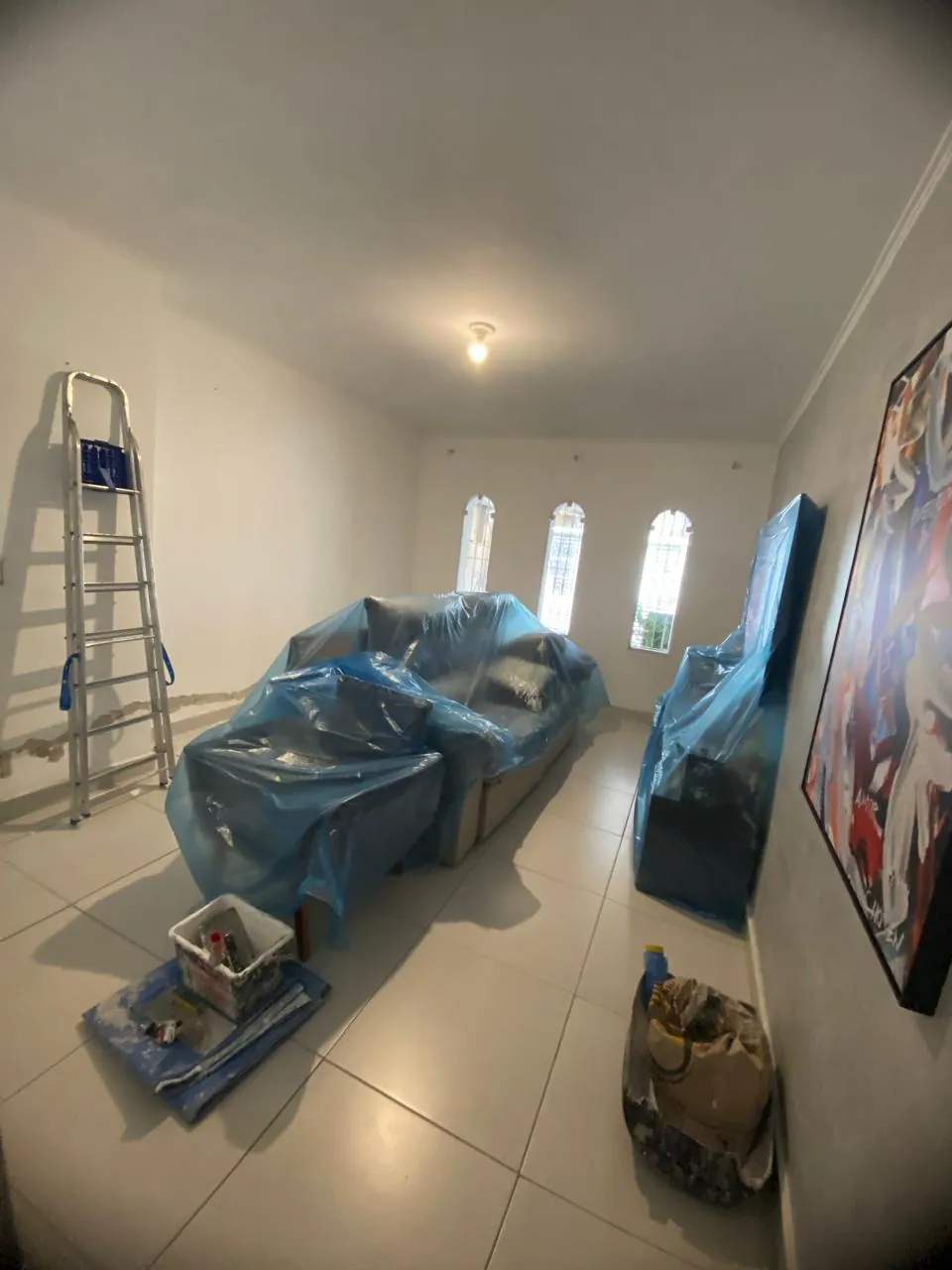 Móveis protegidos com lona antes do início da pintura